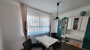 A room with a dining table, two chairs, a bookshelf, and a globe on the wall. - Old kindergarten - now home to Baltic Sea vacationers (Fuhlendorf)
