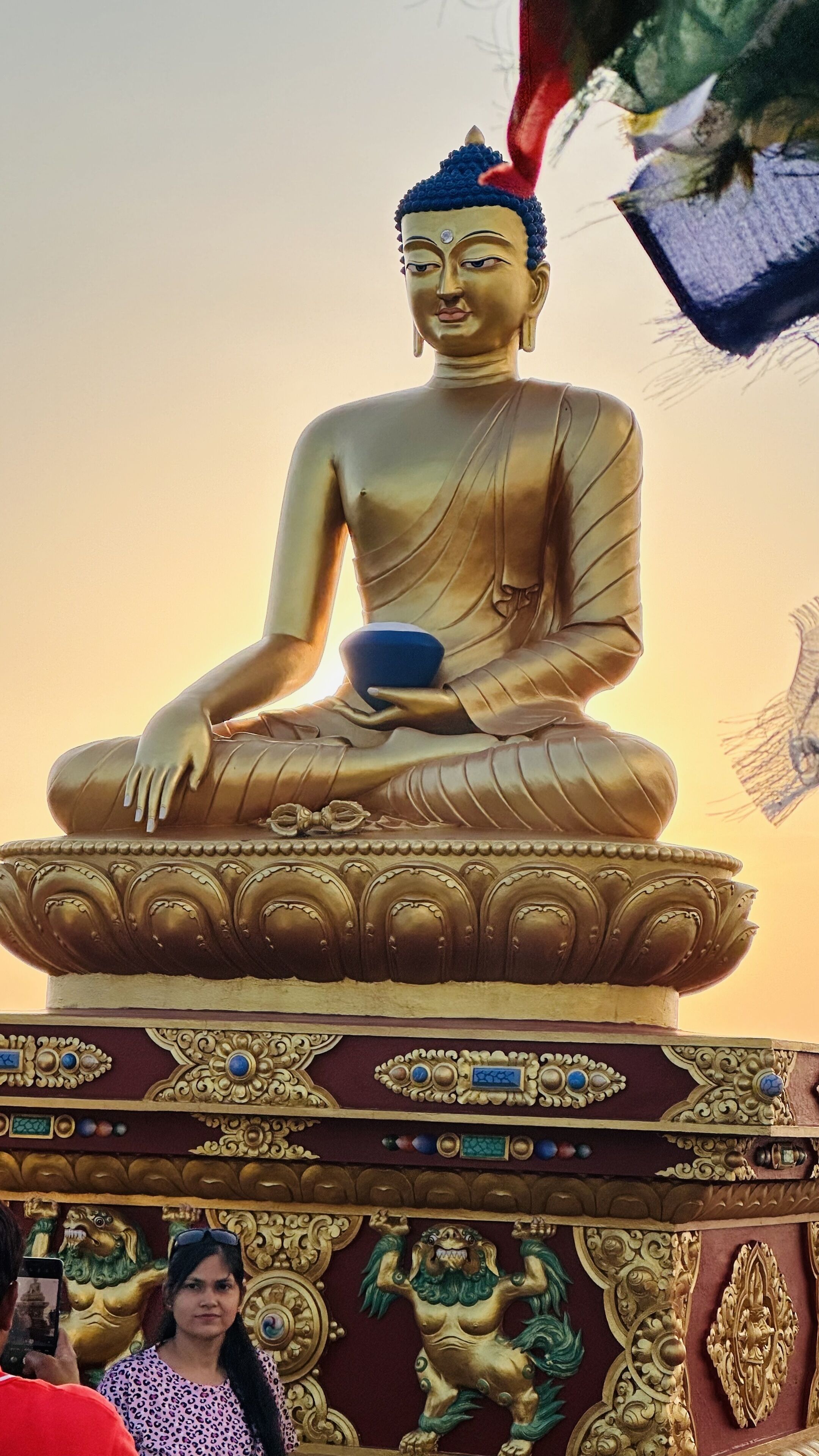 A large golden Buddha statue with intricate base decorations.