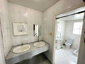 A bathroom with two sinks, a mirror, and a toilet. - Villa 125  (Dubai)