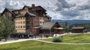 A multi-story hotel with outdoor seating and a view of mountains. - Pinnacle Place Ski-In/Out | Views, Fireplace, Covered Parking, Deck, Hot Tub (Durango)