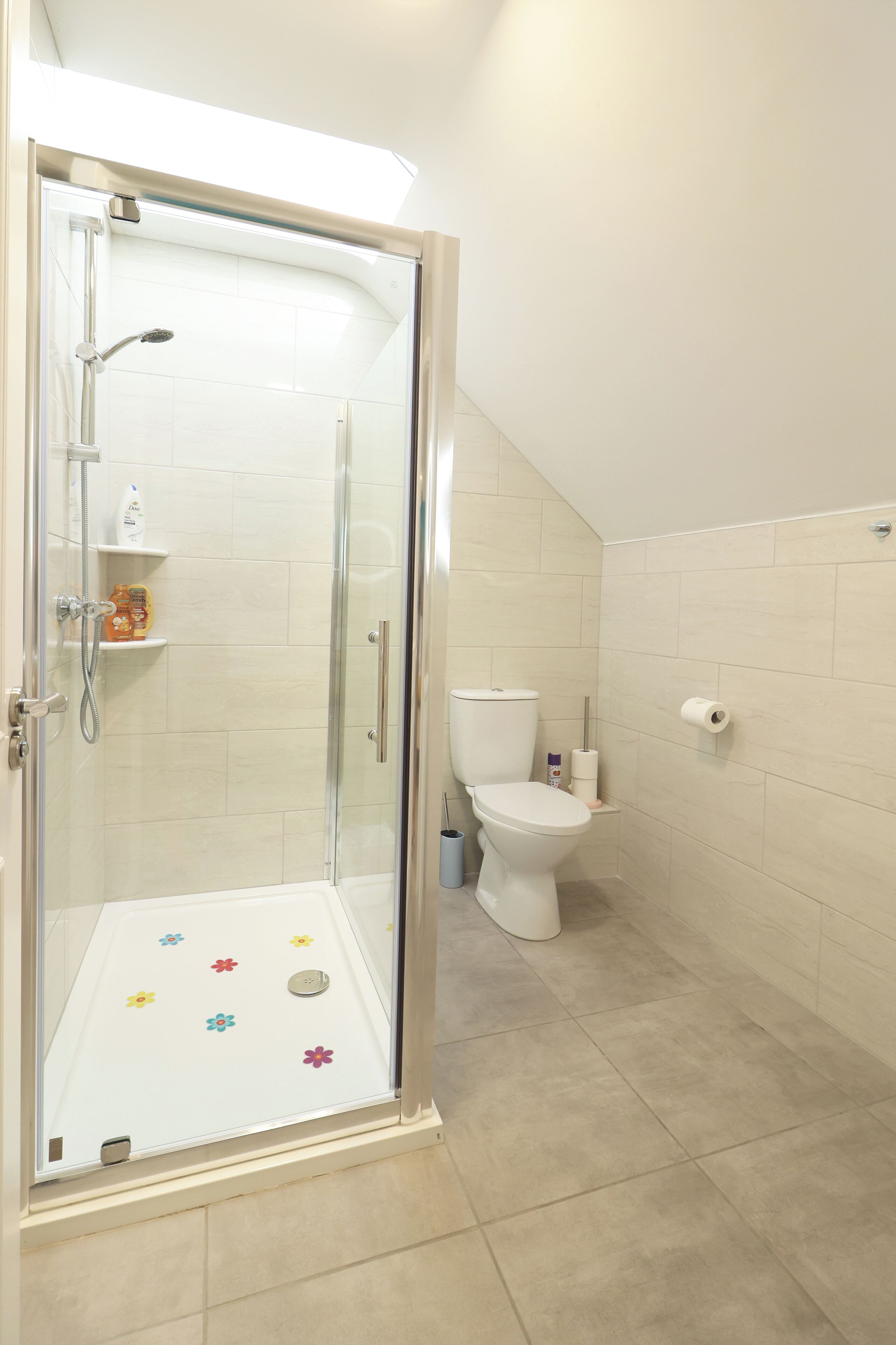 Un bagno moderno con doccia vetro, un water e un lavandino.