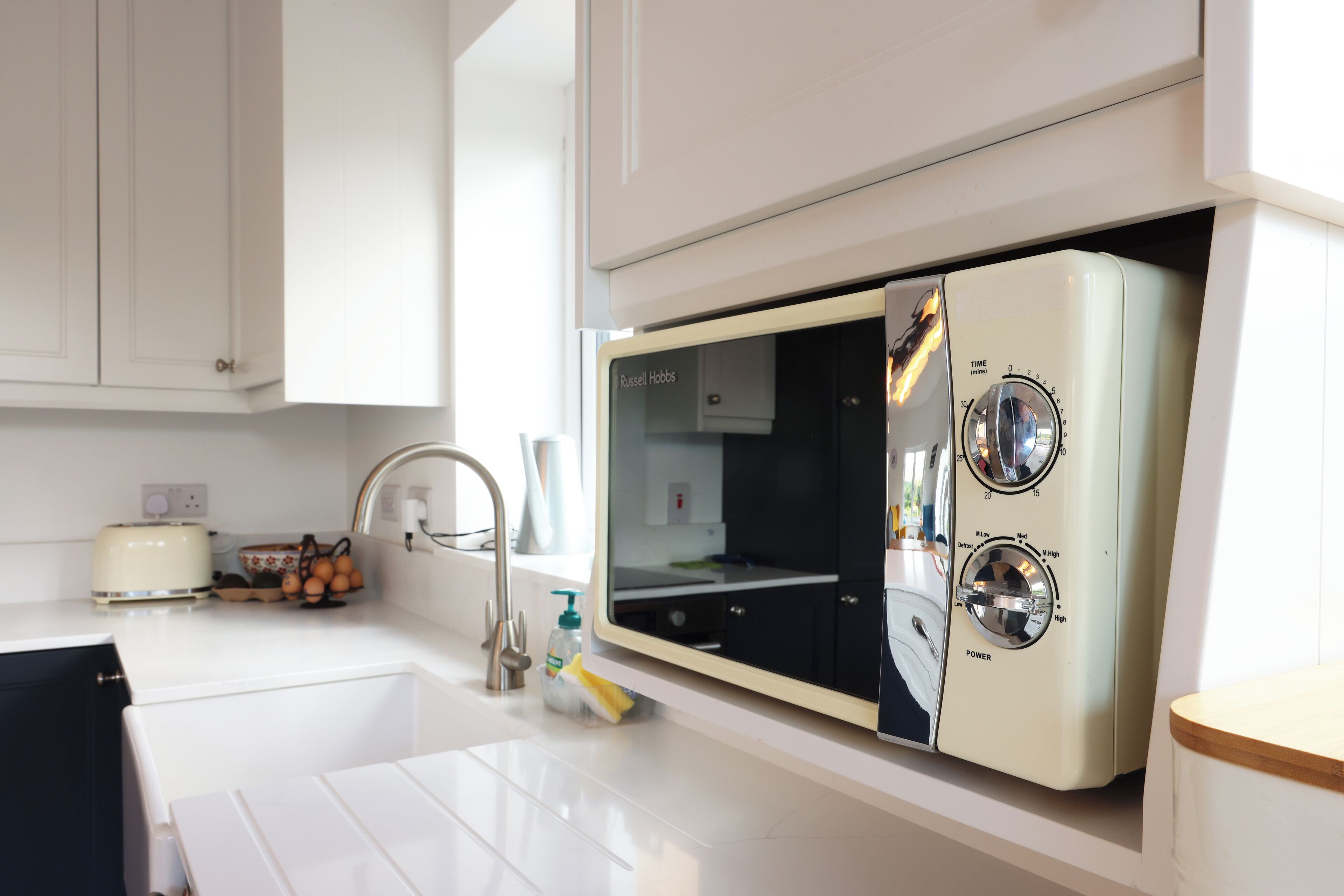 A kitchen with a built-in microwave, a toaster, and a sink.