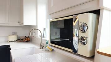 A kitchen with a built-in microwave, a toaster, and a sink.