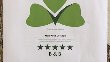 Certificado de aprobación para alojamiento turístico de Mon Petit Cottage, clasificado como casa de huéspedes, con un logotipo verde y firma.