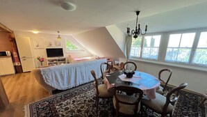 A cozy dining area with a table and chairs, a chandelier, and a view of the outdoors through a window. - Idyllischer Bauernhof 1 (Wildensbuch)