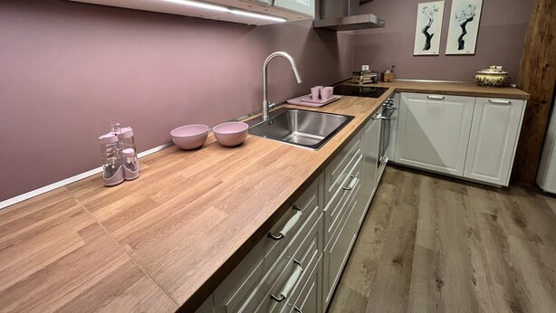 A modern kitchen with a wooden countertop, stainless steel sink, and white cabinets. - Idyllischer Bauernhof 1 (Wildensbuch)