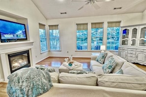 A living room with a fireplace, a television, a sofa, and a cabinet.