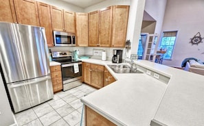 A modern kitchen with stainless steel appliances, wooden cabinets, and a large island.