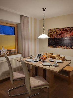 Uma sala de jantar com uma mesa de madeira, cadeiras e um lustre.