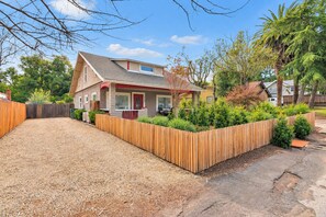 A residential house with a fenced driveway, a front porch, and a well-maintained garden. - Home Squared by LUX Retreats Paso (Paso Robles)
