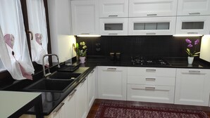 Una cocina moderna con armarios blancos, encimera negra y pileta de acero inoxidable.