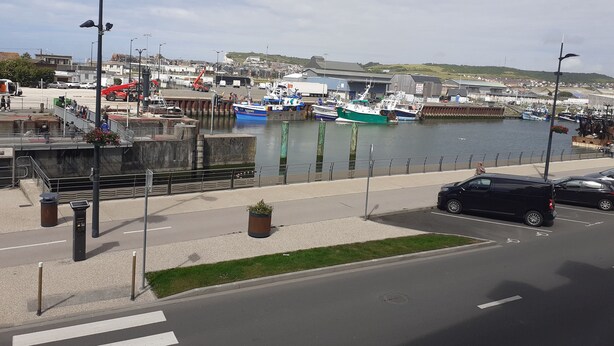 A harbor with boats docked, a pedestrian walkway, and a road with cars. - Cocon Tréportais (76470 Le Tréport)