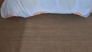 A bedroom with a bed, a lamp, and a door leading to a bathroom. - Cocon Tréportais (76470 Le Tréport)