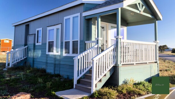 A small, single-story house with a porch and a staircase leading to the front door. - 038 Tiny Home nr Grand Canyon South Rim Sleeps 4 (Williams)