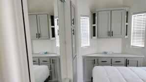A bedroom with a bed, a desk, and cabinets. - 038 Tiny Home nr Grand Canyon South Rim Sleeps 4 (Williams)