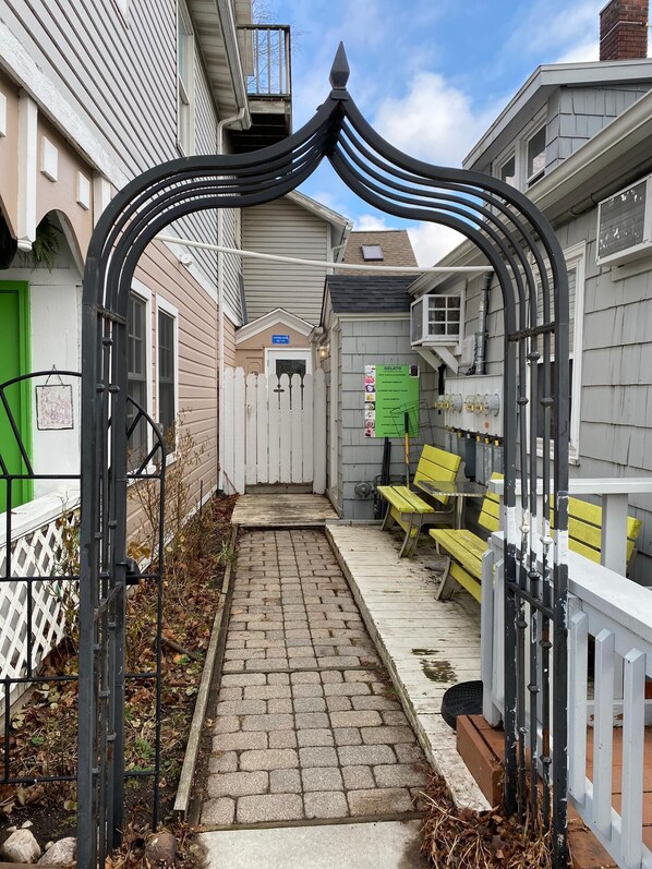 Stroll down the charming pathway to an entrance, flanked by a picket fence and inviting chairs.
