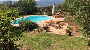 Ein Pool mit Liegestühlen und Blick auf einen Berg.