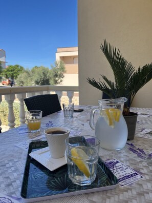A table with a pitcher of water, a cup of coffee, and two glasses on a tray. - Beachfront House Marlot (Razanac)