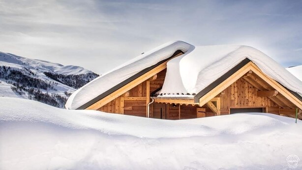 A wooden chalet with a sloped roof, surrounded by snow-covered mountains. - Duplex 6-8 people Saint François Longchamp (Saint-François-Longchamp)