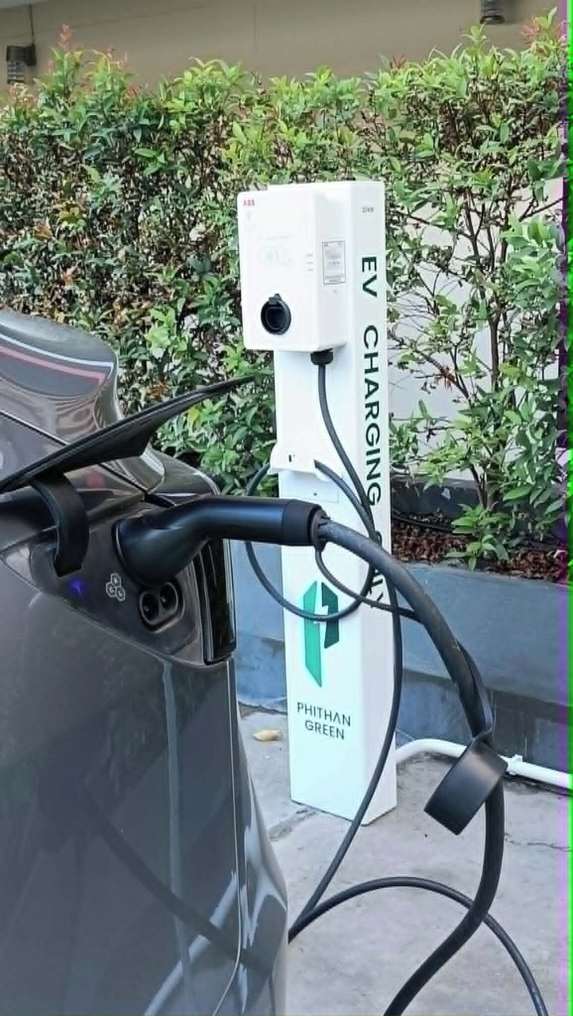 En ladestander til elbil med en kabel forbundet til en bil.
