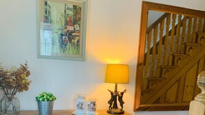 A wooden cabinet with a mirror, a lamp, and decorative items on top.