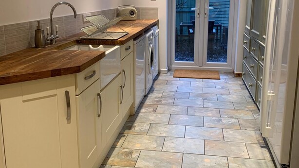 A modern kitchen with a skylight, a built-in washing machine, and a large cabinet.