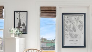 Una silla de madera con cojín en una habitación con paredes blancas y suelo de madera.