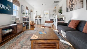 Una sala de estar amplia con un sofá, una mesa de centro y estanterías.