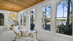 A cozy bedroom with a large bed, a chandelier, and a view of a lake and trees. - ★Luxuriously Romantic One-Of-A-Kind Treehouse w/Canoe, Fire Pit and More★ (Santa Rosa Beach)