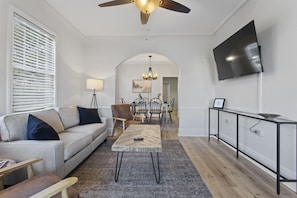 Un salon moderne avec un canapé, une table basse et un téléviseur.