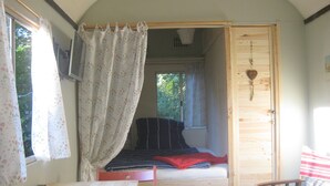 Una habitación pequeña con cama, una mesita y una silla.