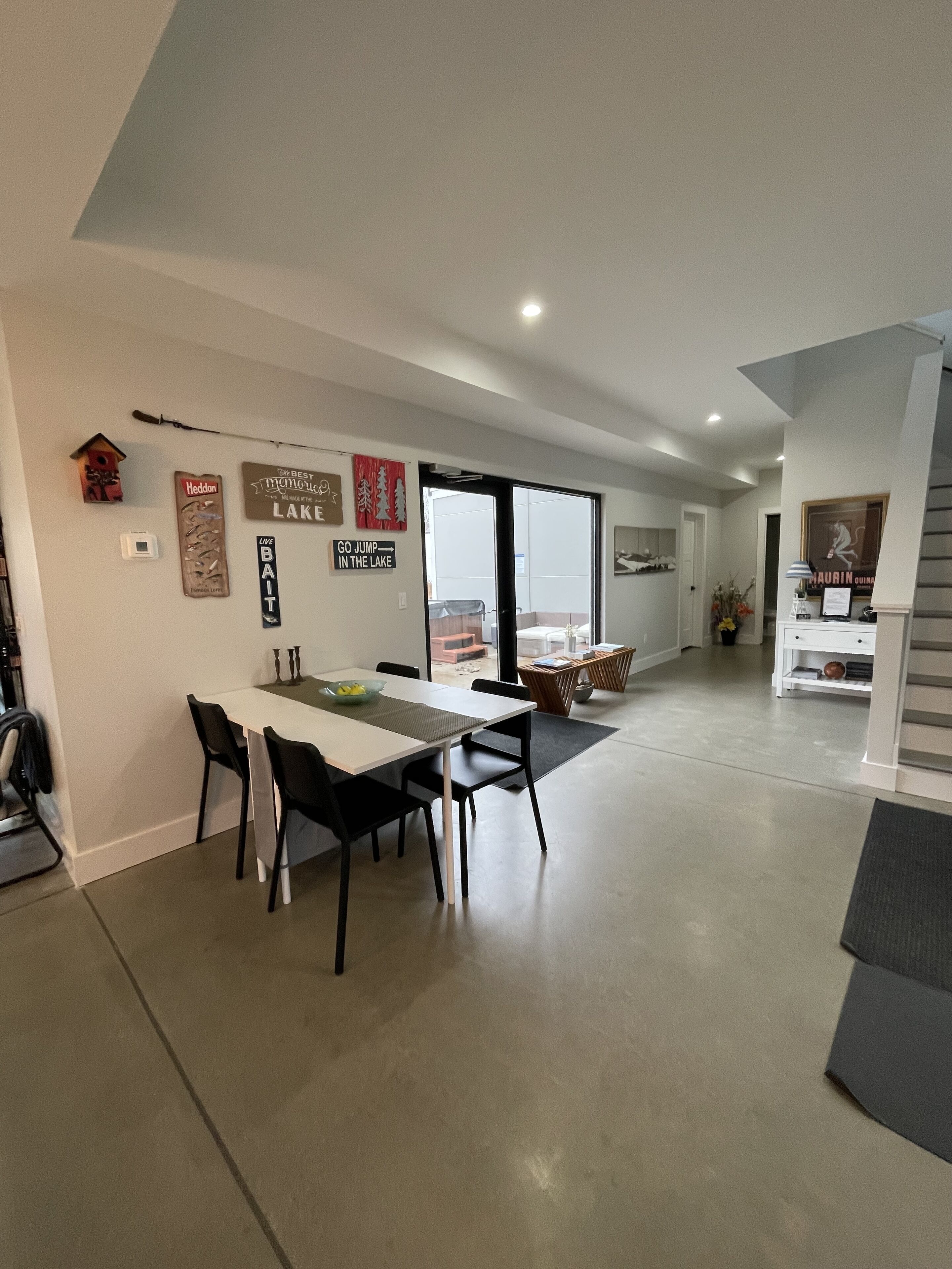 A modern kitchen with a dining area, a staircase, and a view of the outdoors.