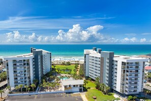 A hotel with multiple floors, a pool area, and a beach view.