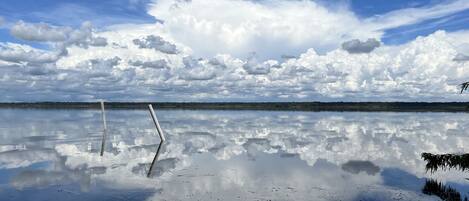 En stilla sjö med en tydlig spegelbild av himlen och molnen.