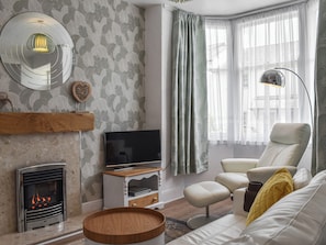 A modern living room with a fireplace, television, and comfortable seating.