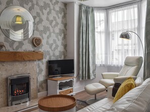 A modern living room with a fireplace, television, and comfortable seating.