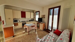A compact living space with a kitchenette, a dining area, and a sofa.