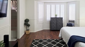 A bedroom with a bed, a dresser, a chair, a plant, and a TV. - Wow! 3BDR Single-story home in Tempe/Chandler (Tempe)