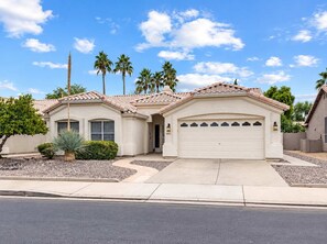 A two-story house with a garage, a driveway, and a well-maintained lawn.