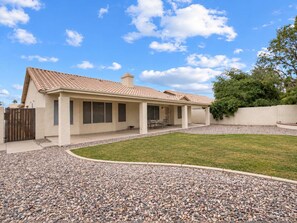 A single-story house with a tiled roof, a covered patio area, and a gravel driveway. - Nice! 5 Bedroom Single-Story Chandler Home (Chandler)