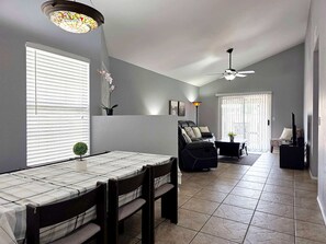 A dining area with a table and chairs, a ceiling fan, and a window with blinds. - Pet-Friendly 3BR | Fenced Yard | King Bed (Chandler)