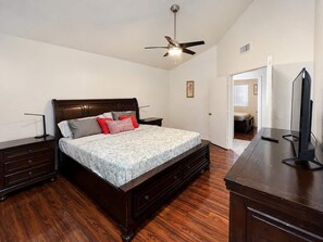 A bedroom with a bed, nightstands, a dresser, a ceiling fan, and a television. - Wow! Single-story 3BR Chandler home (Chandler)