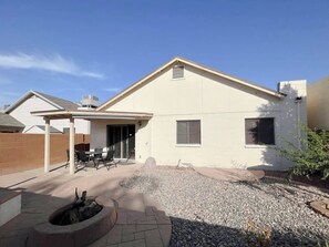 A single-story house with a covered patio, a fire pit, and a gravel driveway. - Wow! Single-story 3BR Chandler home (Chandler)
