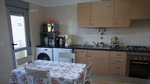 A compact kitchen with a washing machine, a coffee maker, and a gas stove. - Quiet F4 apartment 5 minutes from Olhão town center, Algarve  (QUELFES)