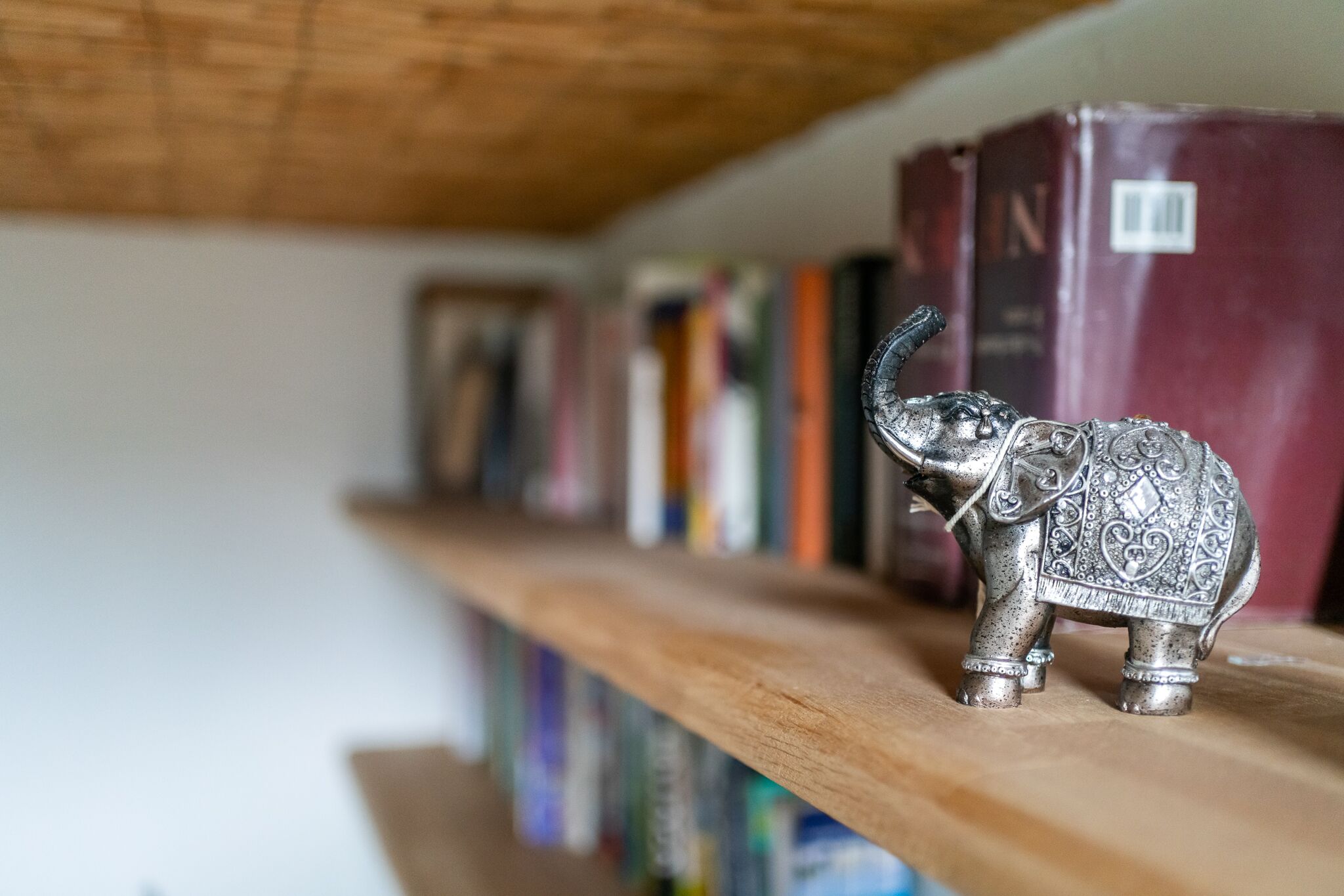 Une étagère ornée d’une statuette d’éléphant décorative et de quelques livres.