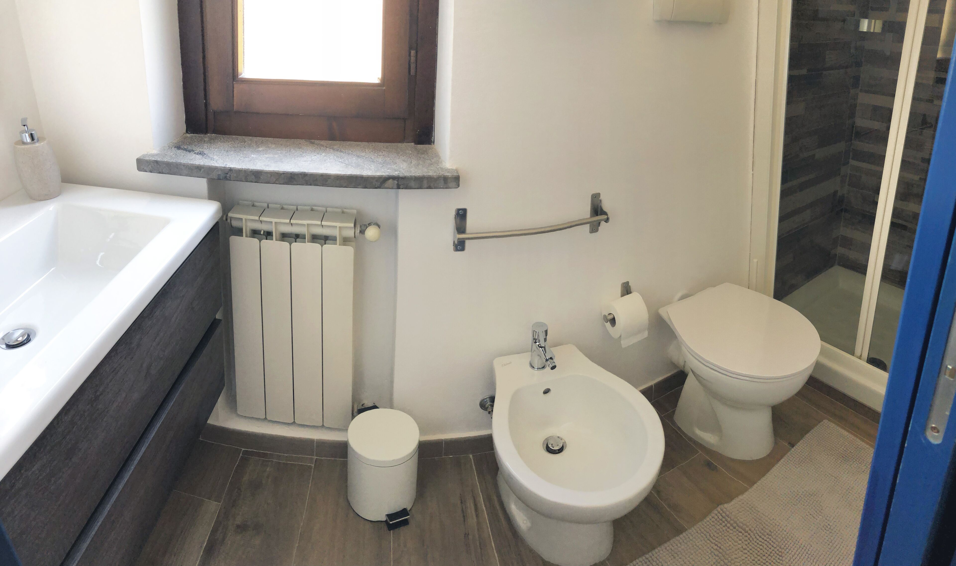 Ein Badezimmer mit Badewanne, Toilette, Bidet und Duschbereich.
