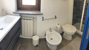 Ein Badezimmer mit Badewanne, Toilette, Bidet und Duschbereich.