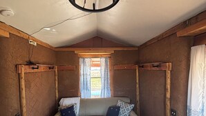 A cozy room with a sofa, a coffee table, and a chandelier. - Anam Cara Vineyard. Romantic Vineyard Cottage with sweeping views (Elgin)