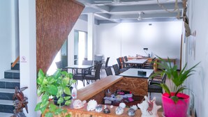Un intérieur moderne avec un escalier, un coin repas et diverses plantes.