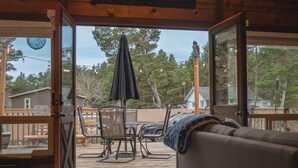 Una terraza abierta con zona de comedor, un espacio de estar cubierto y vistas del vecindario.